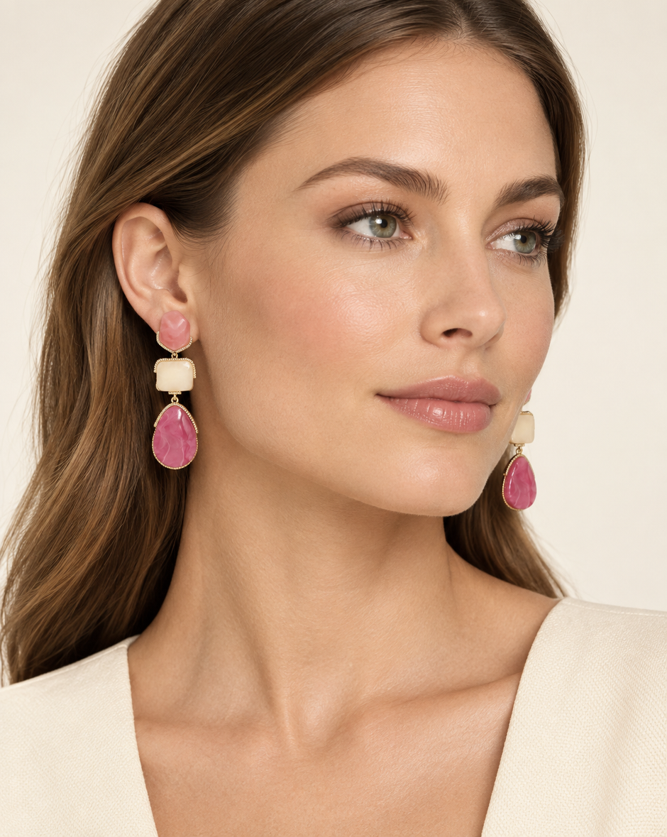 Model wearing pink and ivory resin statement drop earrings with gold-tone trim
