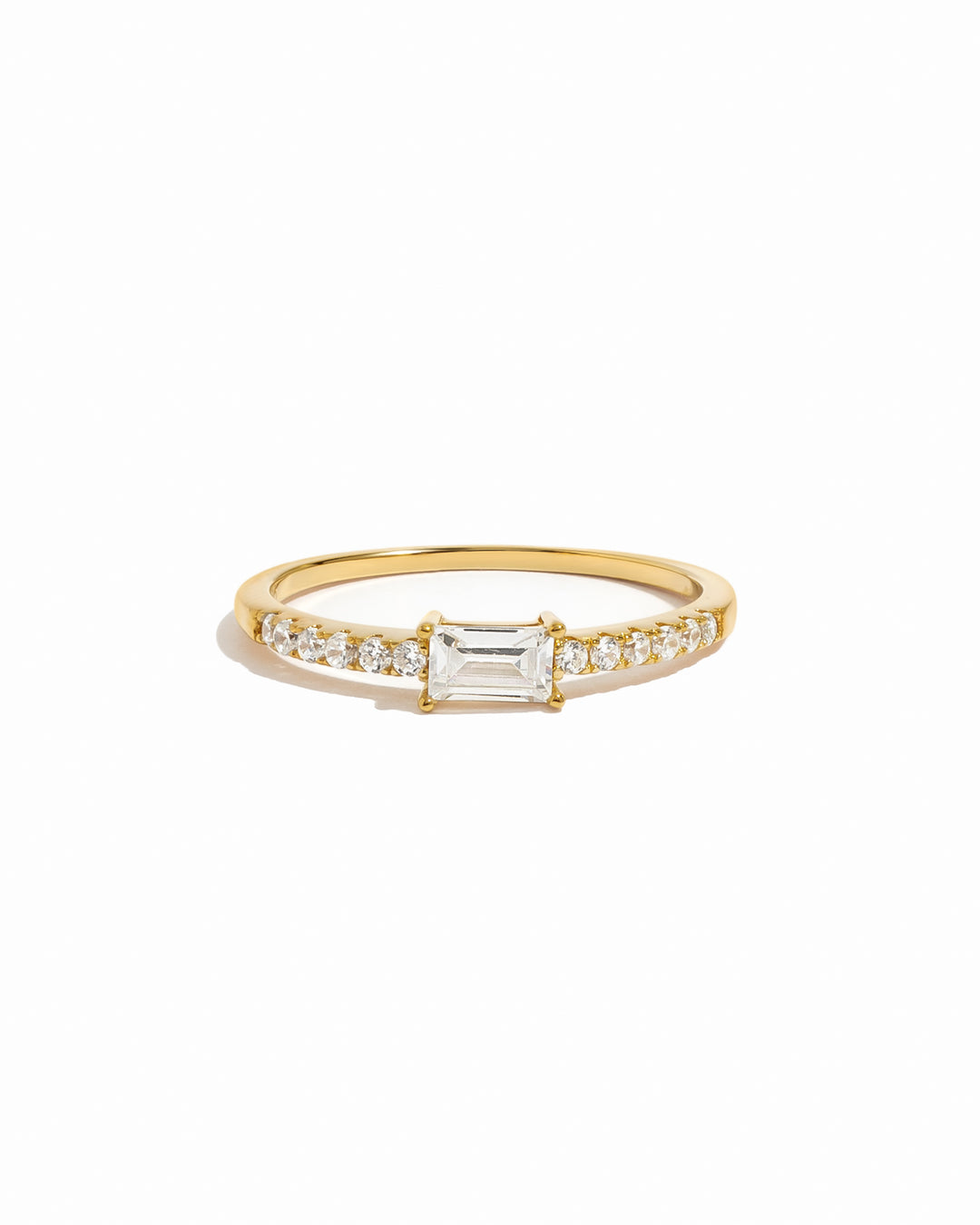 Gold ring with a central diamond and smaller diamonds on a white background