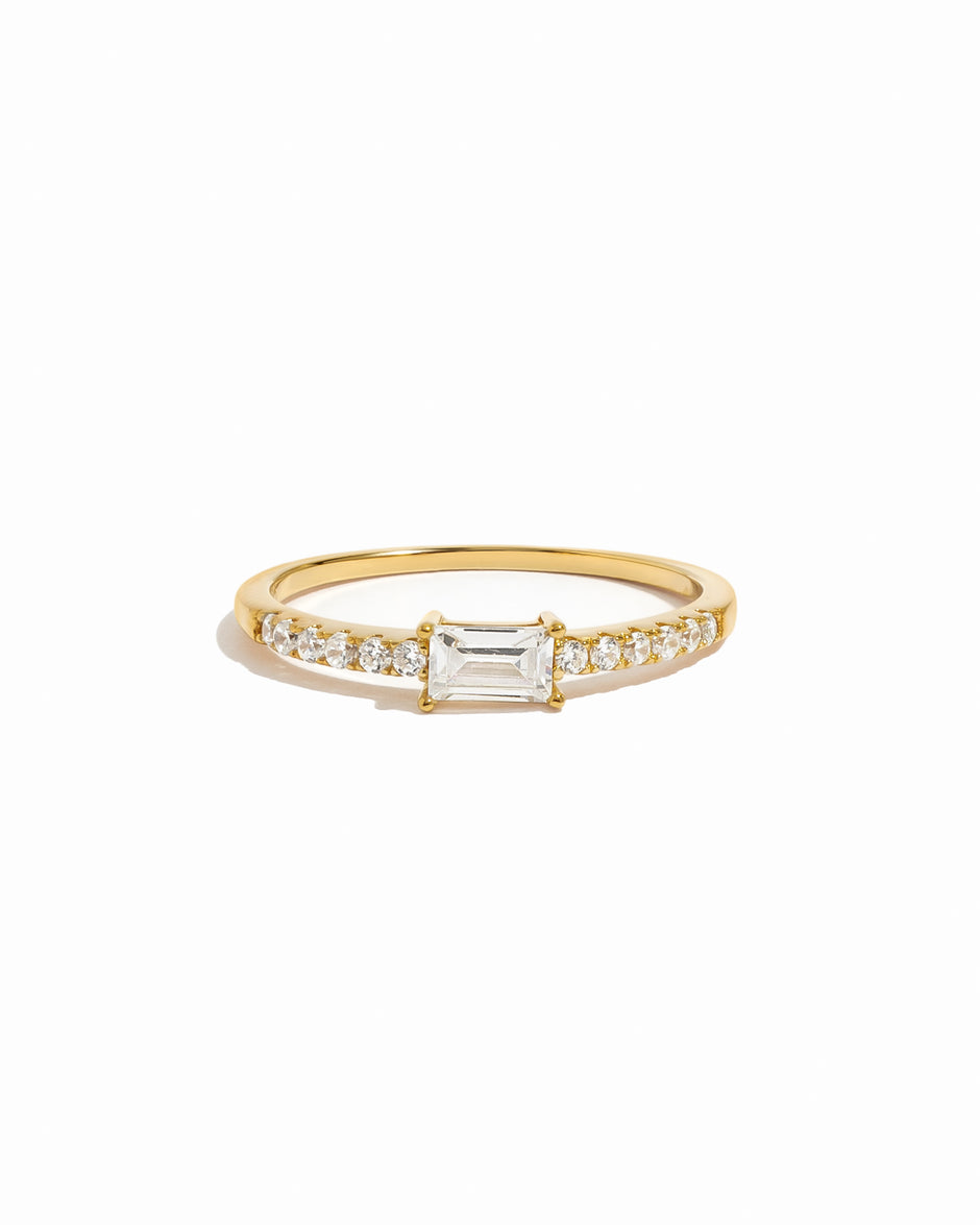 Gold ring with a central diamond and smaller diamonds on a white background